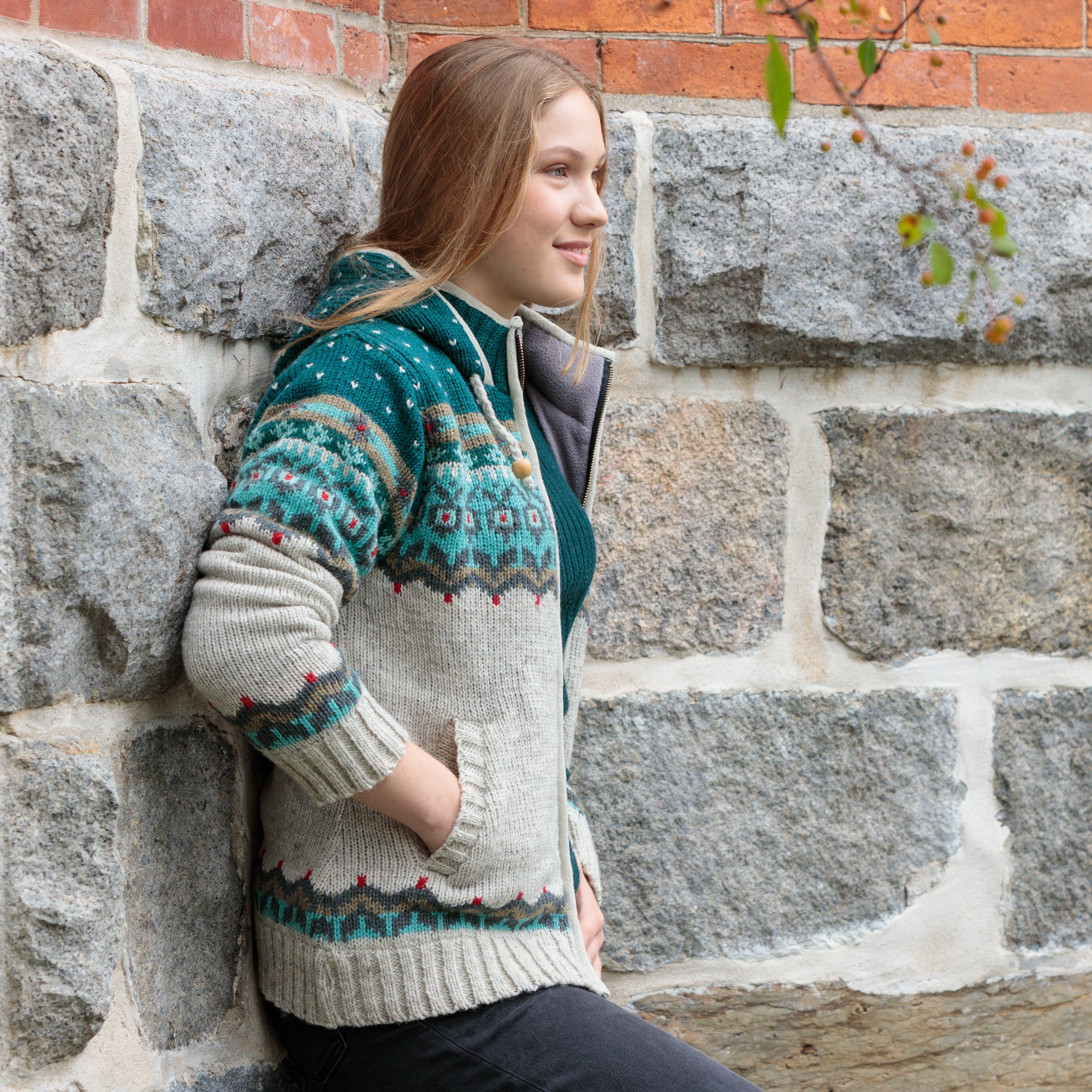 Borealis Handmade wool zip-up sweater with a teal Fair Isle yoke pattern, cream body, and drawstring hood — made in Nepal by Lost Horizons.